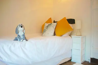a bedroom with a bed with pillows and a zebra toy on it at Romantic* Castle on the Hill Cottage *Framlingham in Framlingham