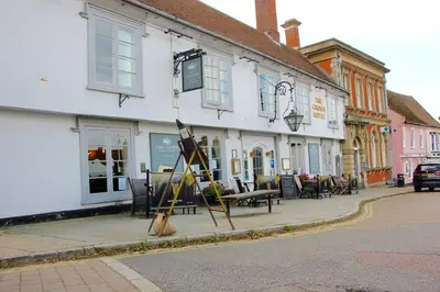 a building on a street with tables and chairs at Romantic* Castle on the Hill Cottage *Framlingham in Framlingham