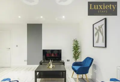 a living room with a blue chair and a table at Stylish 1BR By Luxiety Stays Short Lets & Serviced Accommodation Southend on sea - Near High St & Southend Beach in Southend-on-Sea