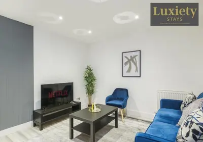 a living room with a blue couch and a tv at Stylish 1BR By Luxiety Stays Short Lets & Serviced Accommodation Southend on sea - Near High St & Southend Beach in Southend-on-Sea