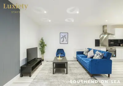 a living room with a blue couch and a table at Stylish 1BR By Luxiety Stays Short Lets & Serviced Accommodation Southend on sea - Near High St & Southend Beach in Southend-on-Sea