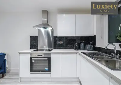 a kitchen with white cabinets and a stove top oven at Stylish 1BR By Luxiety Stays Short Lets & Serviced Accommodation Southend on sea - Near High St & Southend Beach in Southend-on-Sea