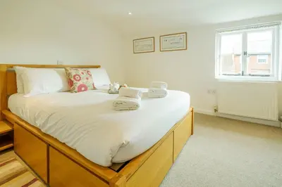 a bedroom with a large bed with towels on it at Poppy Cottage, Aldeburgh - Prime location, close to the beach and High Street - Aldeburgh Coastal Cottages in Aldeburgh