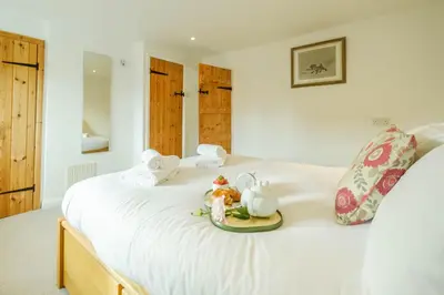 a white bed with a plate of food on it at Poppy Cottage, Aldeburgh - Prime location, close to the beach and High Street - Aldeburgh Coastal Cottages in Aldeburgh