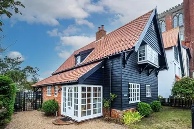 a black house with a red roof at Micawbers - Aldeburgh Coastal Cottages in Thorpeness