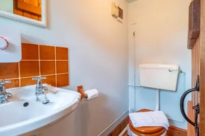 a bathroom with a sink and a toilet at Micawbers - Aldeburgh Coastal Cottages in Thorpeness