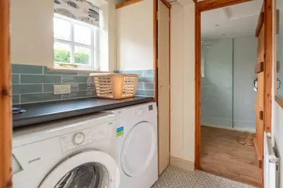 a laundry room with a washer and dryer at Micawbers - Aldeburgh Coastal Cottages in Thorpeness
