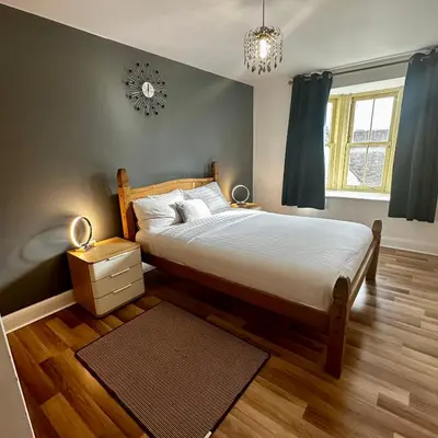 a bedroom with a bed and a clock on the wall at Two Bedroom Flat Town Centre Colchester in Colchester