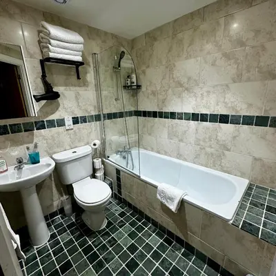 a bathroom with a tub and a toilet and a sink at Two Bedroom Flat Town Centre Colchester in Colchester