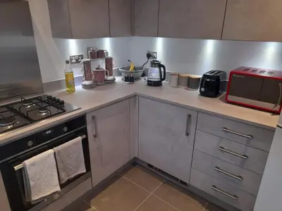 a kitchen with a stove and a microwave at Beautiful Double Bedroom- In a modern 2 bed shared house in Chigwell