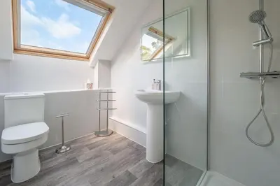 a bathroom with a toilet and a glass shower at Maltings Lodge in Chelsworth