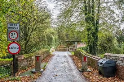 a dirt road with a sign on the side at Maltings Lodge in Chelsworth