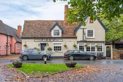 two cars parked in front of a building at Maltings Lodge in Chelsworth