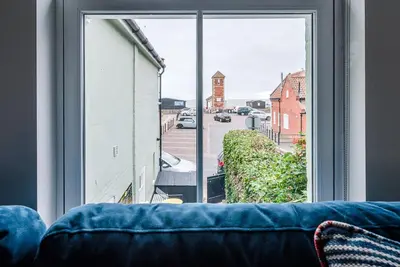 a view of a street from a window with a couch at Pebble View, Aldeburgh in Aldeburgh