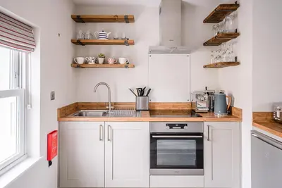 a kitchen with white cabinets and a sink at Pebble View, Aldeburgh in Aldeburgh
