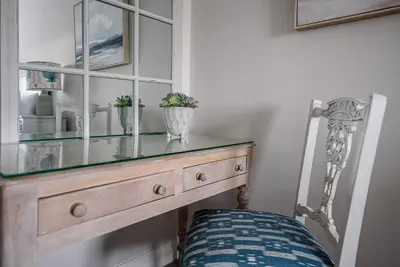 a glass cabinet with two plants on top of it at Pebble View, Aldeburgh in Aldeburgh