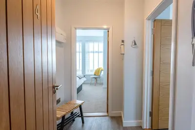a hallway with a door leading to a living room at 4 Buregate House, Felixstowe in Felixstowe