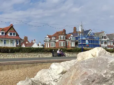 a couple sitting on a bench in front of houses at 4 Buregate House, Felixstowe in Felixstowe
