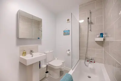 a bathroom with a sink and a toilet and a shower at 4 Buregate House, Felixstowe in Felixstowe