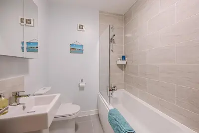 a bathroom with a sink and a toilet and a bath tub at 4 Buregate House, Felixstowe in Felixstowe