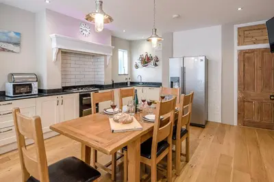a kitchen with a wooden table and chairs in a kitchen at 4 Market Cross House, Aldeburgh in Aldeburgh