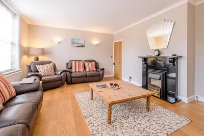a living room with a couch and a table at 4 Market Cross House, Aldeburgh in Aldeburgh