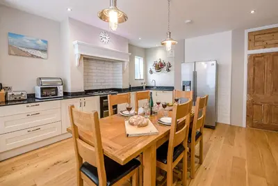 a kitchen with a wooden table and chairs in a room at 4 Market Cross House, Aldeburgh in Aldeburgh