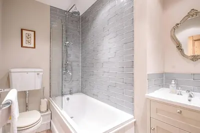 a bathroom with a tub and a toilet and a sink at 4 Market Cross House, Aldeburgh in Aldeburgh