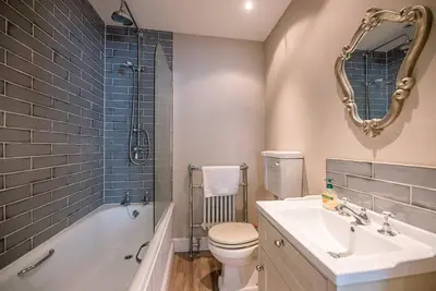 a bathroom with a sink and a toilet and a tub at 4 Market Cross House, Aldeburgh in Aldeburgh