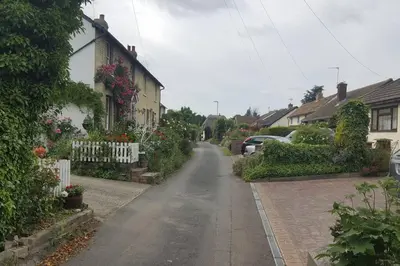 an empty street in a residential neighborhood with houses at Entire Thatched Cottage in Melbourn