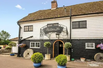 a building with a sign on the front of it at Entire Thatched Cottage in Melbourn