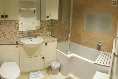 a bathroom with a sink and a toilet and a tub at Entire Thatched Cottage in Melbourn