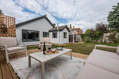 a patio with a white table and two chairs at Festival House, Snape in Saxmundham