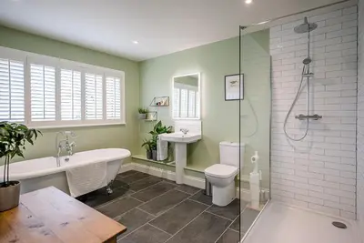 a bathroom with a tub and a toilet and a sink at Festival House, Snape in Saxmundham