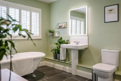 a bathroom with a tub and a sink and a toilet at Festival House, Snape in Saxmundham