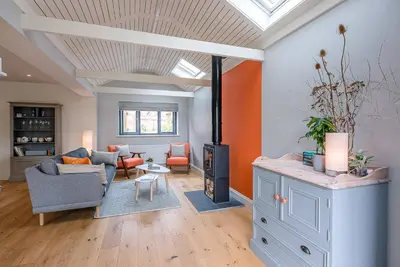 a living room with a couch and a fireplace at Festival House, Snape in Saxmundham