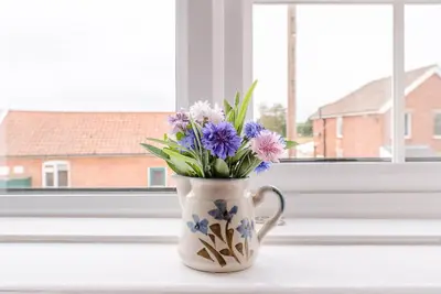 a vase filled with flowers sitting on a window sill at North Cottage, Alderton in Woodbridge