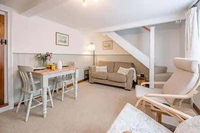 a living room with a table and a couch at North Cottage, Alderton in Woodbridge
