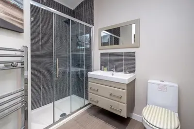 a bathroom with a toilet and a sink and a shower at Chelsea Lodge - Aldeburgh Coastal Cottages in Sizewell