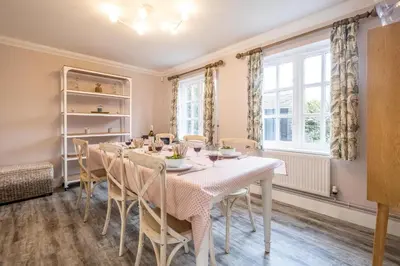 a dining room with a table and chairs at 1 Sanctuary Court - Aldeburgh Coastal Cottages in Thorpeness