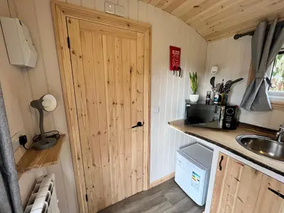 a kitchen with a door in a tiny house at Wildflower Meadow Cabins in Whitington