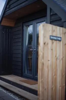 a house with a door with a sign on it at Wildflower Meadow Cabins in Whitington