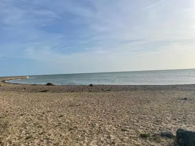 an empty beach with the ocean in the background at Summer Breeze Deluxe Caravan Rental in Saint Osyth