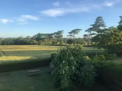 a park with two benches in the grass at The Artist's House, Orford in Orford