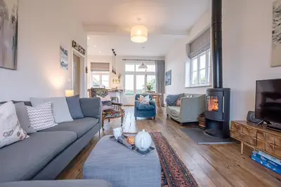 a living room with a couch and a tv at The Artist's House, Orford in Orford