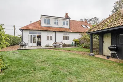 a white house with a yard with a grill at The Artist's House, Orford in Orford