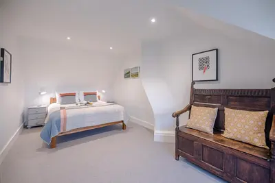 a bedroom with a bed and a bench in it at The Artist's House, Orford in Orford