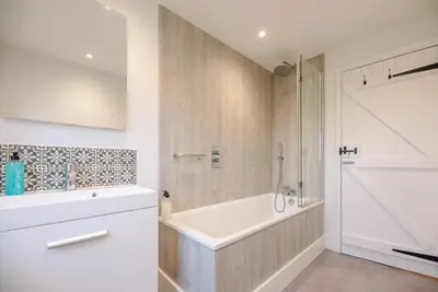 a white bathroom with a tub and a shower at The Artist's House, Orford in Orford
