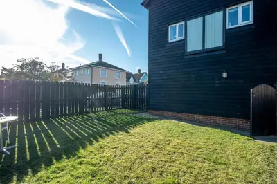 a fence in a yard next to a house at The Britten - Aldeburgh Coastal Cottages in Aldeburgh