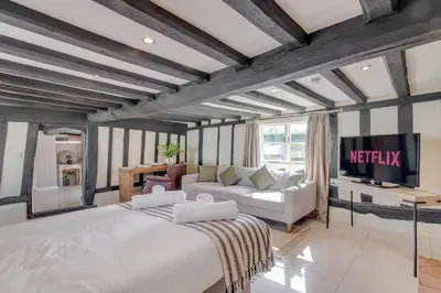 a bedroom with a large bed and a couch at 5 Bedroom House in Larling, near Thetford in Norwich